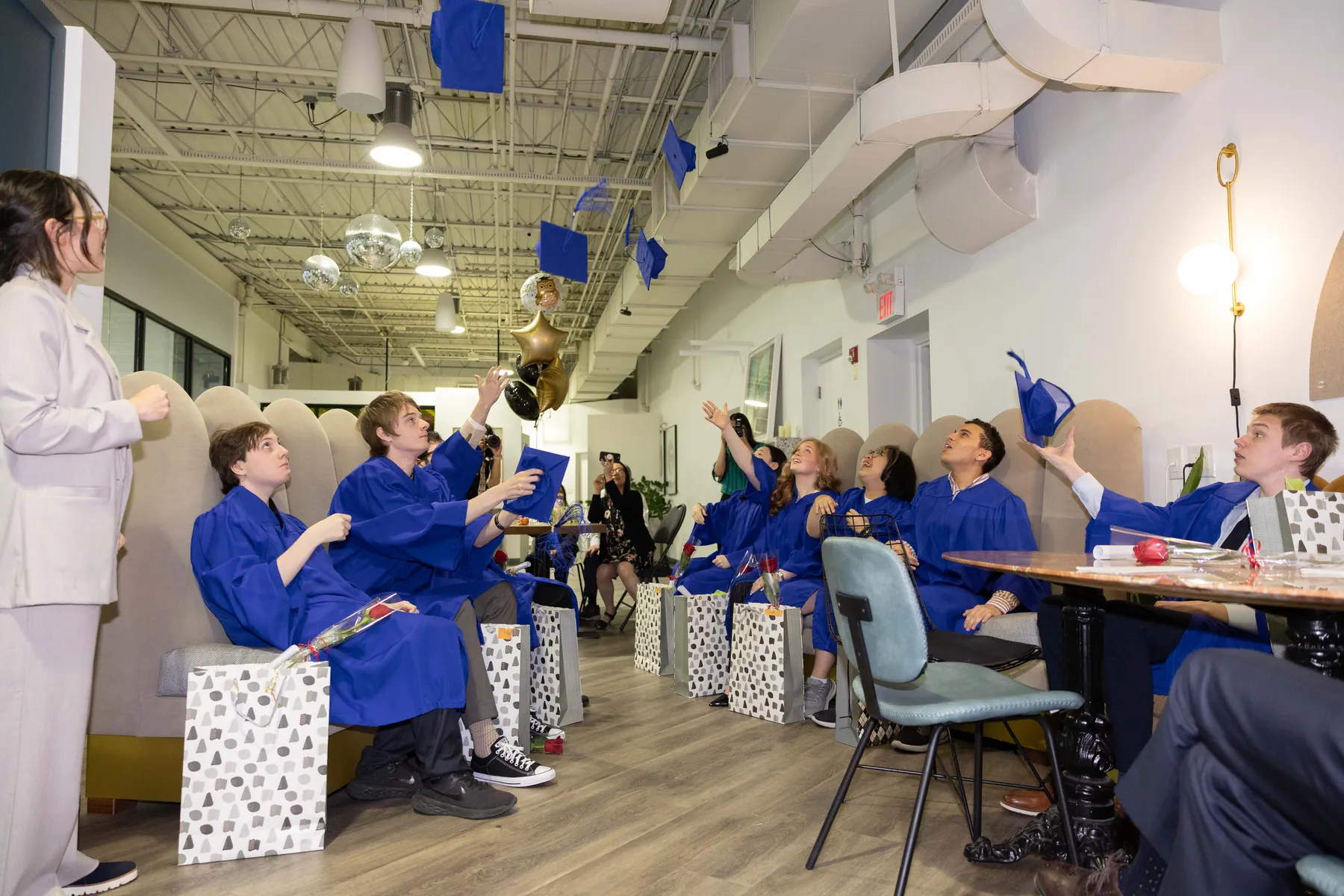 AVRO Academy students throwing their graduation caps in celebration