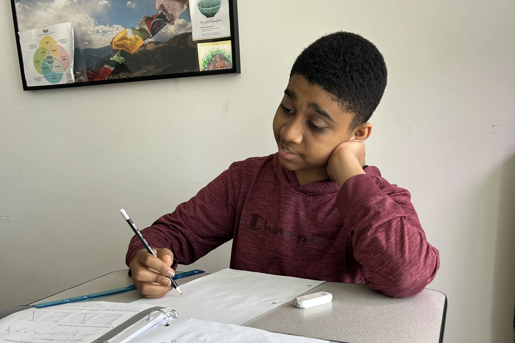 An AVRO Academy student writing at their desk