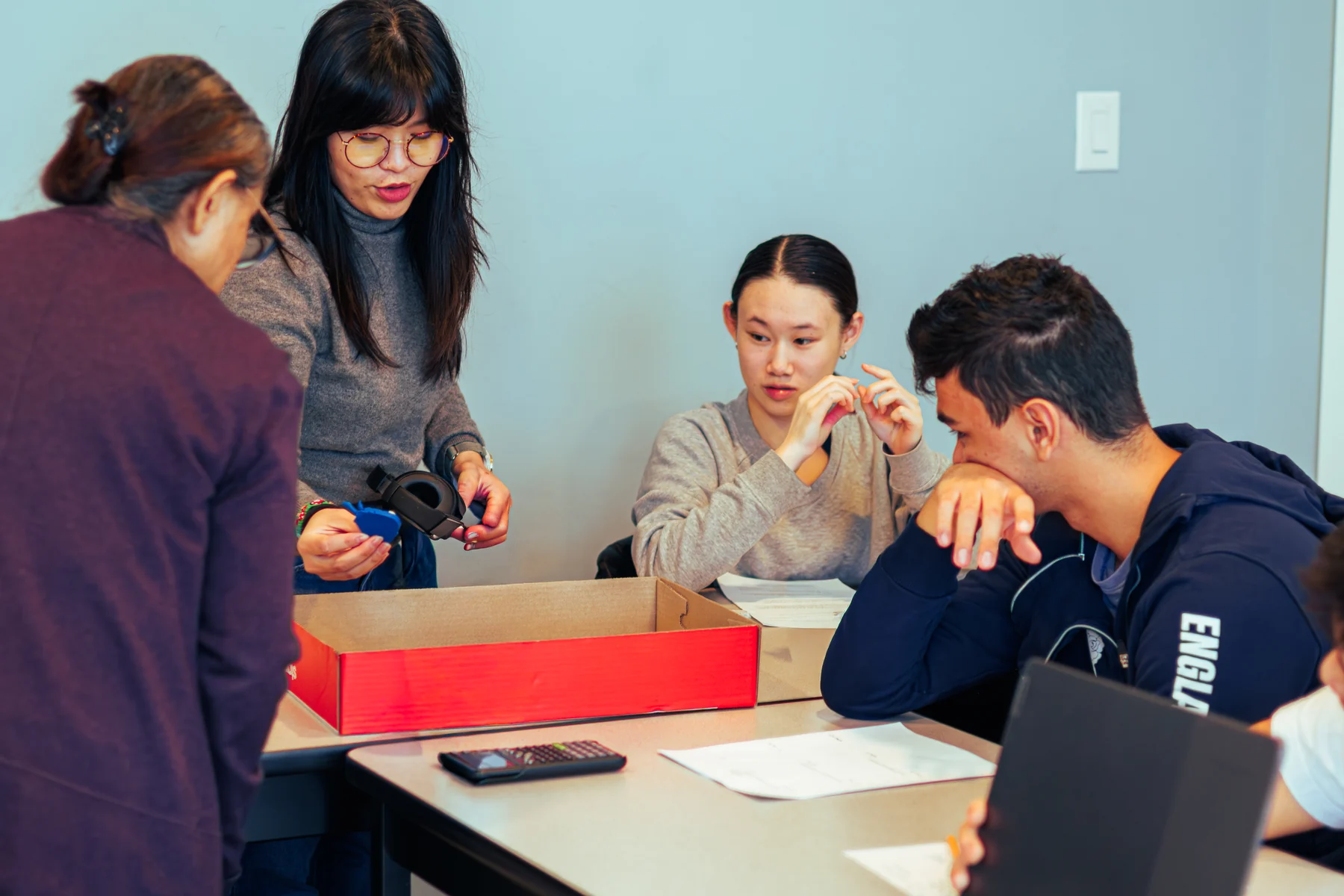 An AVRO Academy teacher guiding students through a hands-on project