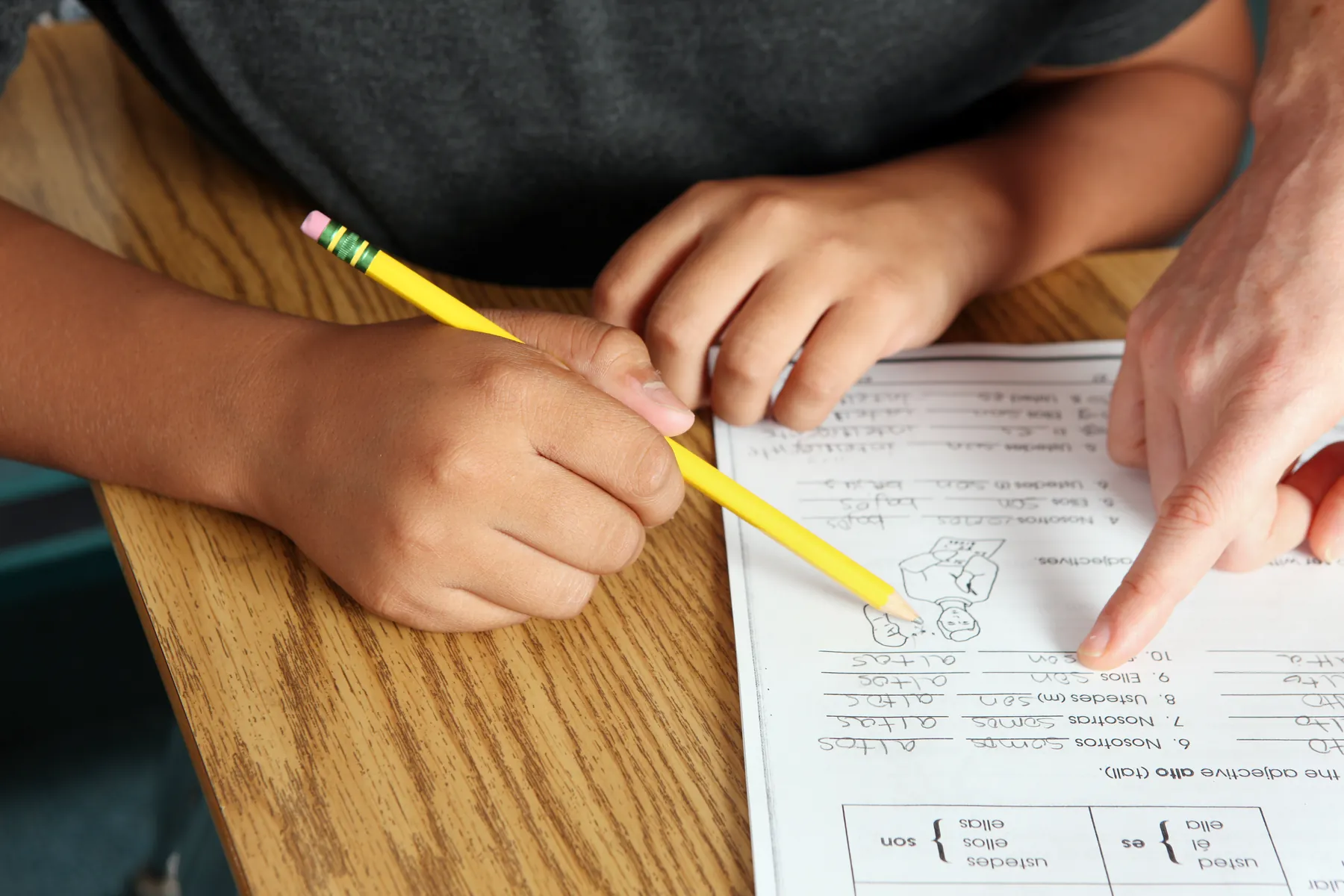 A student receiving one-to-one worksheet guidance at a desk